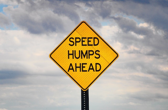 Yellow road sign that says "Speed humps ahead"
